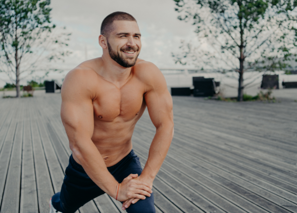 Sportlicher Mann macht Dehnübungen – Beckenbodentraining für Männer